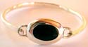 Sterling silver bangle with elliptical shape black onyx stone embedded in middle
