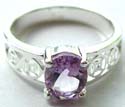 Sterling silver ring holding an oval shape light purple cz in middle with carved-out Celtic pattern design on both sides