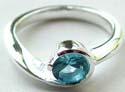 Curved-in pattern design sterling silver ring holding a rounded blue cz stone in middle