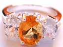 Sterling silver ring holding an oval orange cz in middle sided with an oval clear cz