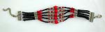 Multi black beads forming 5 strings fashion bracelet, 5 strings holding together by silver strip, bigger red beads in middle are connected by silver bead cap