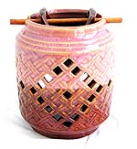 Oriental double pot style ceramic oil burner with pink color carved out retan pattern and a wooden stick