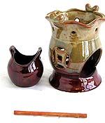 Oriental double pot style ceramic oil burner with carved out coin pattern and a wooden stick