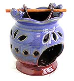 Ceramic flower pot oil burner with carved out pattern and a wooden stick