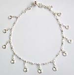 Sterling silver anklet with double circle pattern and a mini bell at the end