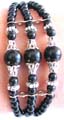 Silver stripped triple black beaded strings fashion bracelet holding 3 black, flower silver beads and large silver capped black color beads at center