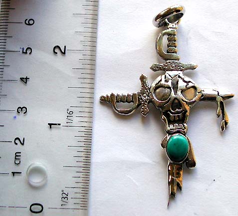 925. sterling silver pendant in carved-out skull on sword cross pattern design with an oval shape blue turquoise stone embeddded        

