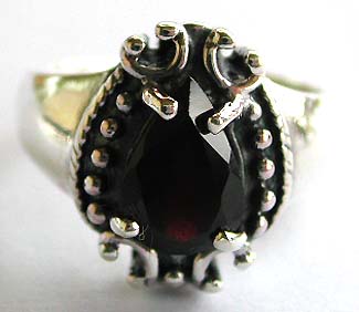 Sterling silver ring with dotted pattern around water-drop shape red garnet at center