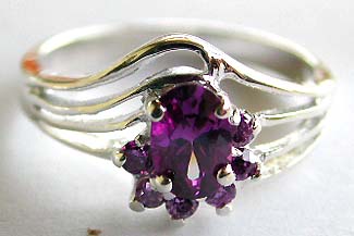 Your silver ring source for retail wholesaler offer sterling silver ring holding a oval shape purple cz stone in middle and 6 mini cubic zirconia synthetic gemstone around top 
