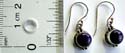 Sterling silver fish hook earring with rounded dark purple stone inlay at center