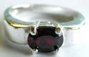 Sterling silver ring with an elliptical shape red garnet stone inlay in middle