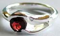 925. sterling silver ring with carved-out double wavy pattern hodling a rounded red garnet stone in middle 