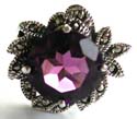 Sterling silver ring with multi marcasite stone embedded grape leaf pattern decor holding an oval shape amethyst stone in middle