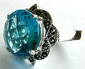 Multi marcasite stone embedded flower pattern decor 925. sterling silver ring holding a rounded blue cz stone in middle