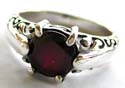 925. sterling silver ring with a rounded garnet stone inlay at center and carved-out pattern on top and bottom