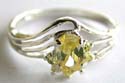 Carved-out wavy pattern decor sterling silver ring holding a oval shape yellow cz stone in middle and 6 mini cz around top 