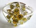 Sterling silver ring with carved-out line pattern holding multi mini yellow cz stone forming flower decor at center