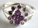 Sterling silver ring with carved-out line pattern holding multi mini purple cz stone forming flower decor at center