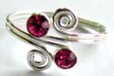 Sterling silver toering in double spiral pattern design holding 2 pink color cz stone in middle