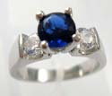 Fashion ring with sapphire-blue ring in center with two rounded clear cz beside, made rhodium plated and brass base 