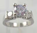 Rhodium plated in brass base ring with lavender rounded cz in center, one clear cz on each side 