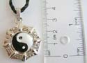Fashion necklace with black twisted cord string holding Yin-Yang mental pendant at center