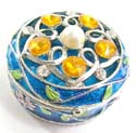 Round enamel jewelry box motif filigree flower holding 5 orange shiny beads and a pearl bead inlaid on lid with pinky flower decor around, enamel in blue color