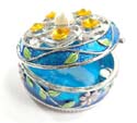 Round enamel jewelry box motif filigree flower holding 5 orange shiny beads and a pearl bead inlaid on lid with pinky flower decor around, enamel in blue color