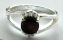 Sterling silver ring with carved-out Y shape pattern holding a rounded red garnet stone at center