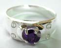 Sterling silver ring with a rounded purple color amethyst stone at center and 4 mini pattern decor on each corner