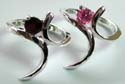 Sterling silver ring with curvy stand central design holding a rounded pinkish cz / red garnet stone in middle