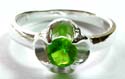 Sterling silver ring with a rounded green cz stone embedded flower pattern decor at center