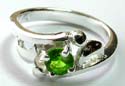 Sterling silver ring with carved-out double mini moon and circle pattern design holding arounded green cz stone in middle