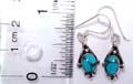 Diamond shape design sterling silver earring with an oval shape blue turquoise stone embedded in middle and dotted pattern decor on bottom
