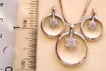 Silver frame holding clear cz flower surrounded pendant necklace and earring set 