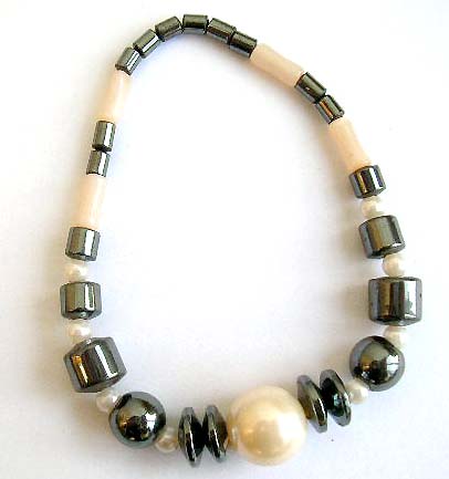 Hematite stretchy bracelet with multi short cylinder shape hematite and white beads holding 2 black pearl beads, quadrate flat disk beads and a white pearl bead at center