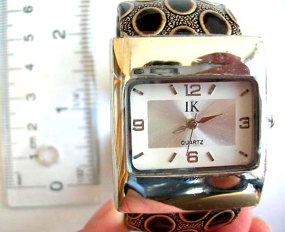 Fashion bangle watch with rectangular clock face design and elliptical pattern decor on color band