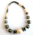 Hematite stretchy bracelet with multi short cylinder shape hematite and white beads holding 2 black pearl beads, quadrat flat disk beads and a white pearl bead at center