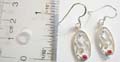 Sterling silver fish hook earring curved out with flower pattern and holding a mini red cz at bottom