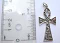 Sterling silver pendant in cross design with various symbles on one side.