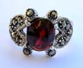 Multi marcasites beaded cut-out heart pattern sterling silver ring with a red oval garnet stone set in middle 
