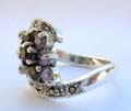 Central open design sterling silver ring with rounded purple, clear, and blue cz stone embedded line-up in middle and marcasites on top and bottom end 