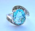 Central open design sterling silver ring with a oval light blue cz stone embedded in middle and marcasites on top and bottom end 