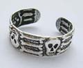 Sterling silver toe ring with carved-out skull and bone pattern decor around 