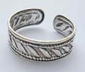 Sterling silver toe ring with carved-out line and leaf pattern decor around 