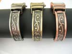 Bronze, copper and yellow bangle watch with long rectangular shape and line pattern design on bangle