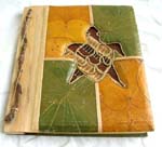 Rectangular photo album with tree stick on side and turtle central design, made of natural material such as banana leaf, mulberry papers, recycling papers, etc. 