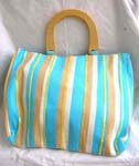 Fabric blue wooden handle hand bag with blue, white and nature color line section and yellow sparkle chips thread work design, also inside zipper pocket, cell phone pocket and zipper closure