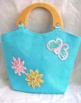 Blue canvas fabric with sequins double wooden handle hand bag motif pink and yellow flowers with butterfly on right hand side in sparkle chips and thread work design, also zipper closure and inner zipper pocket