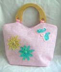 Pinky canvas fabric with sequins double wooden handle hand bag motif green and yellow flowers with butterfly on right hand side in sparkle chips and thread work, also zipper closure and inner zipper pocket 